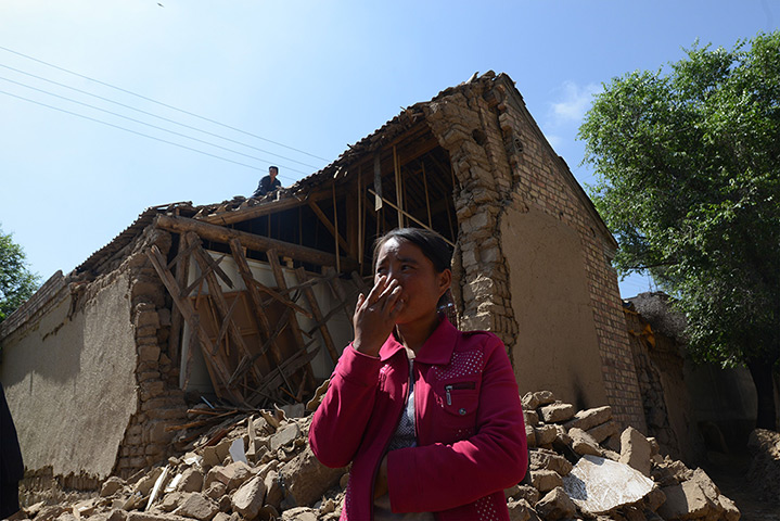 China earthquake: A local resident stands in front of a badly damaged house in Meichuan towns