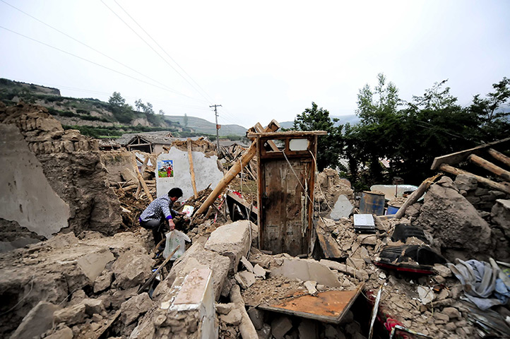 China earthquake: A woman works in the rubble of damaged houses in Meichuan township in Dingx