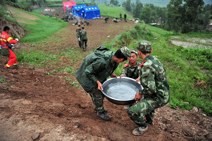 China earthquake: Rescuers carry water as earthquake relief efforts continue in Yongguang tow