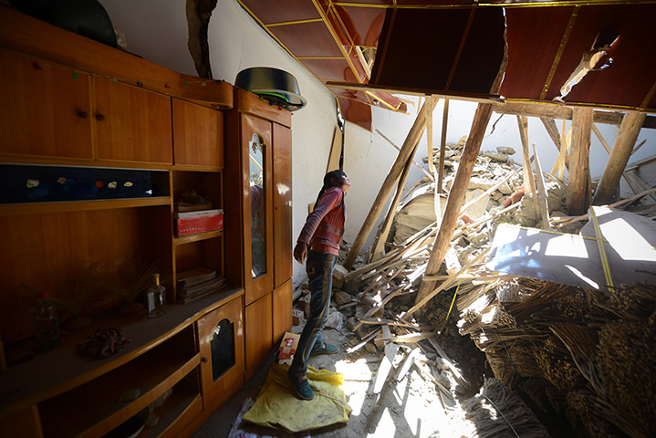 China earthquake: Local resident Yang Suxia searches through the remains of her house in Meic