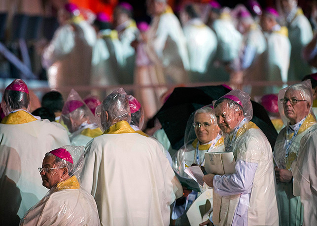 Pope in Brazil: Bishops wearing plastic rain hoods attend the World Youth Day inaugural Mas