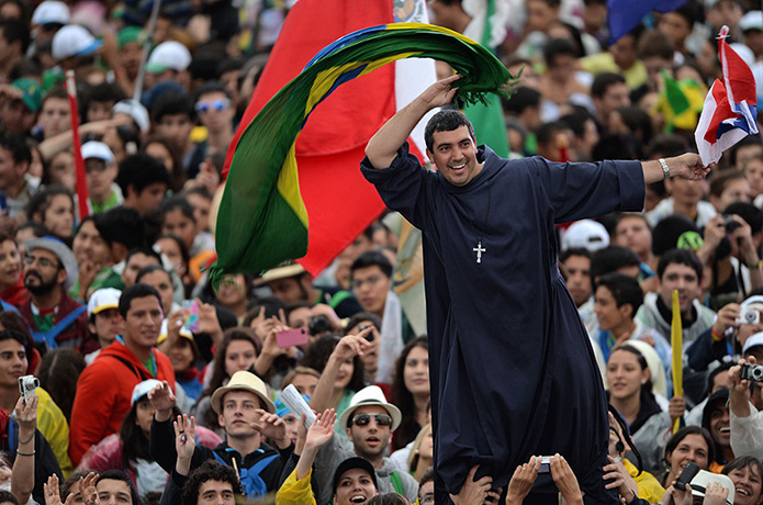 Pope in Brazil: A man waves a Brazilian and a Chilean flag as he waits at Copacabana b