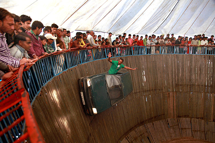 eyewitness tradition: A performer rides the wall of death in a car at the Jhiri fair in Jammu