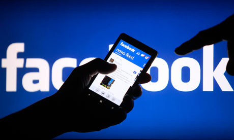 A smartphone user shows the Facebook application on his phone