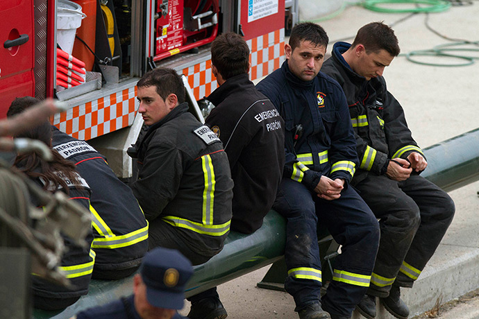 Spanish train update: Emergency personnel take a break while working at the site of a train accid