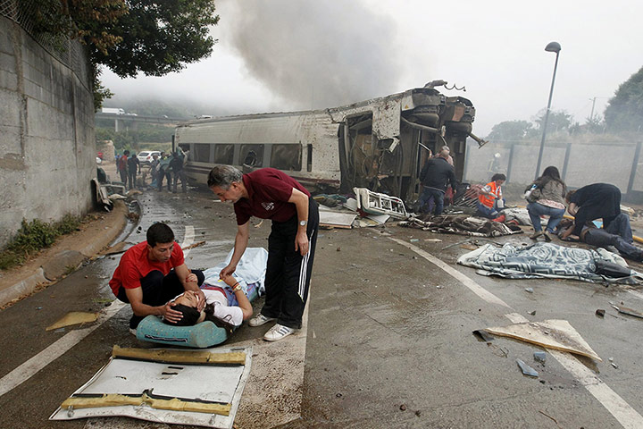 20 Photos: 2 men comfort a woman next to a derailed car near Santiago de Compostela