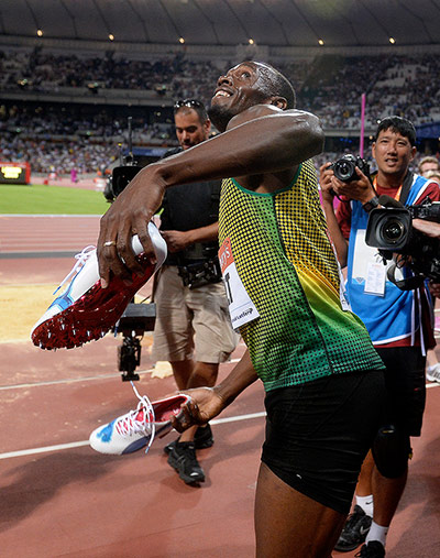 Day 1 Anniversary games: Usain Bolt prepares to throw his spikes into the crowd 