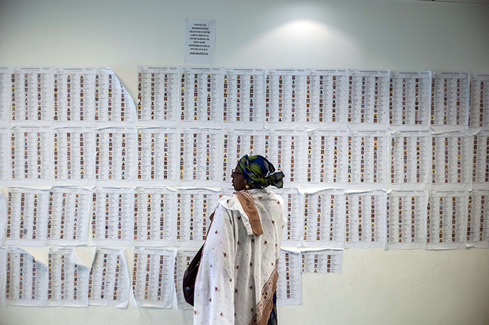Weekend in pictures: Bagnolet, Paris: A woman looks at the list of biometric voters at the Malia
