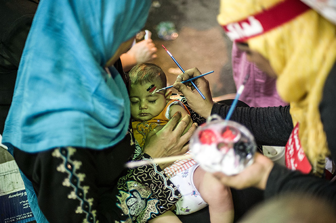 Weekend in pictures: Cairo, Egypt: A woman paints an Egyptian flag on a baby's face during a ral