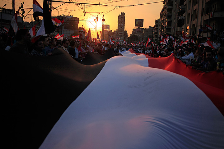 Protests in Egypt: Opponents of President Morsi carry a large national flag during a protest o