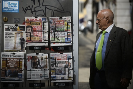 A man looks at daily newspapers with front pages carrying headlines concerning the resignation of Portuguese Foreign Minister and the political crisis in Portugal, in Lisbon on July 3, 2013.