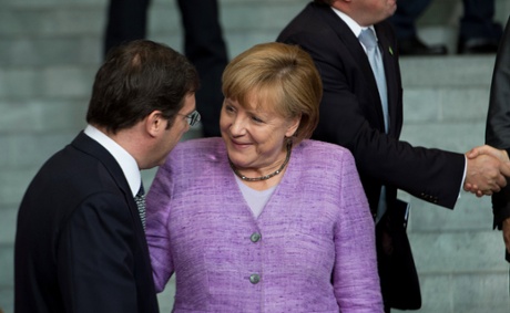 German Chancellor Angela Merkel and Portuguese Prime Minister Pedro Passos Coelho (L) speak after they pose for a family picture with the head of states and ministers after a conference on promoting youth employment in Europe on July 3, 2013 in the chancellory in Berlin.