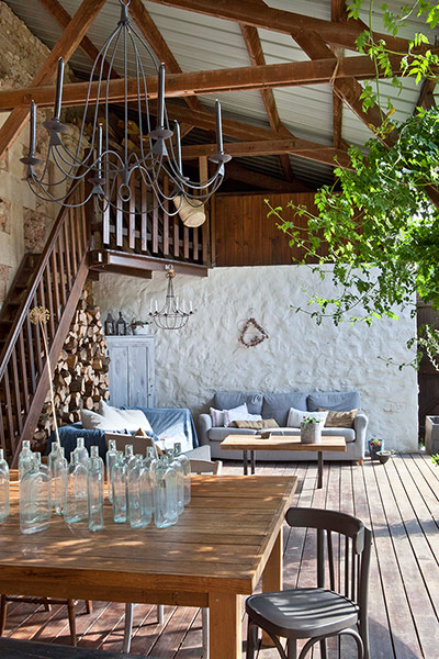homes - stylists feature: terrace area with wooden table and glass bottles