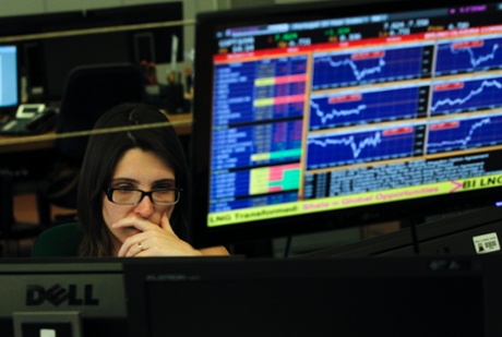 A broker works in a trading room of a Portuguese bank in Lisbon, Wednesday, July 3, 2013.