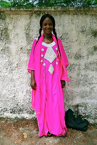 Big Picture - Africa: woman in pink dress standing in front of wall