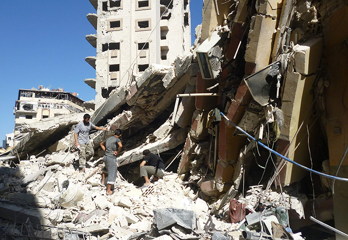 Homs destruction: People search for survivors at a site hit by a missile attack from the Syri