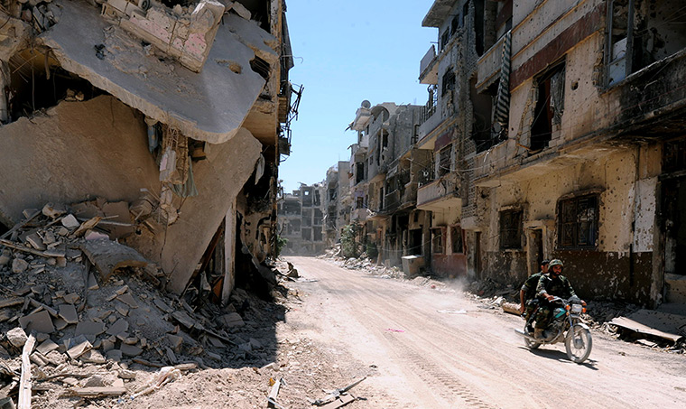 Homs destruction: Syrian army soldiers patrol in the street of Khalidiyah July 30.  The Syria