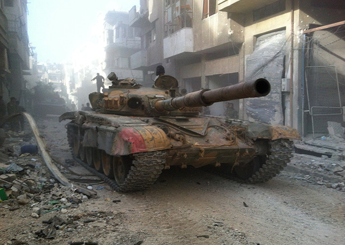 Homs destruction: A Syrian government forces tank rolls in the Khalidiyah district, July 29, 