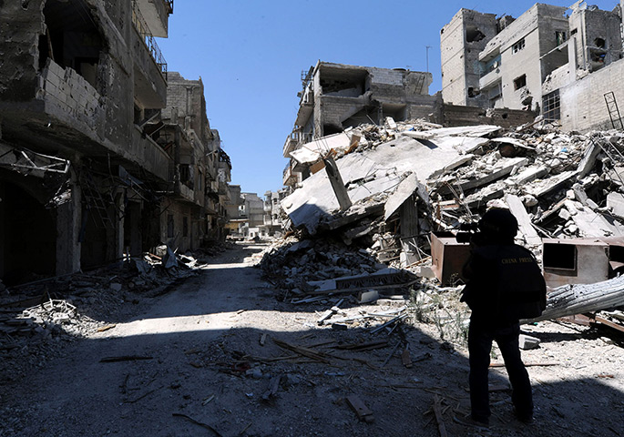 Homs destruction: A Chinese journalist works in a steet of the al-Khalidiya district