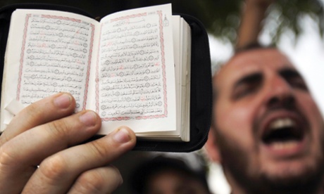 A member of the Muslim Brotherhood and supporter of the ousted Egyptian President Mohamed Mursi holds a copy of the Koran while shouting slogans during the swearing in ceremony of the head of Egypt's Constitutional Court Adli Mansour as the nation's interim president in Cairo.