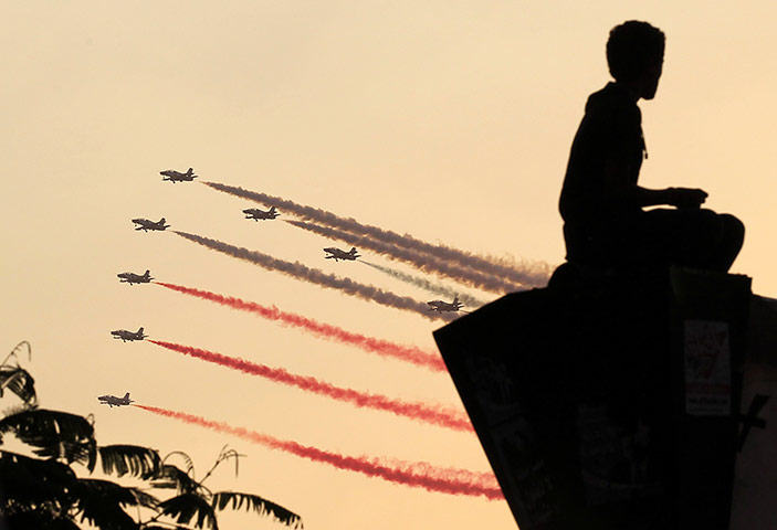 Egypt Update: A man is silhouetted as Egyptian military jets fly by