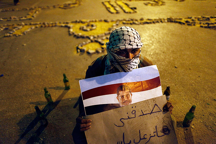 Egypt Update: An egyptian man holds ousted president Mohammed Morsi portrait