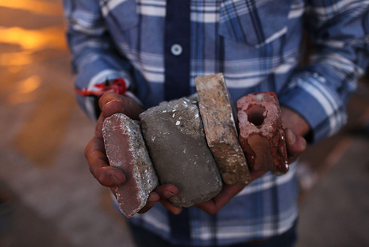Egypt Day 3: A youth holds concrete pieces and bricks during clashes in Tahrir square