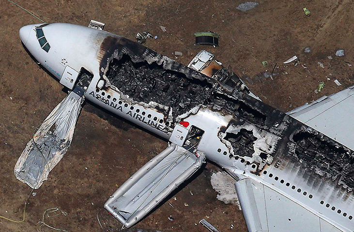 Asiana plane crash: Rescue officials stand near an Asiana Airlines Boeing 777 plane after it cr