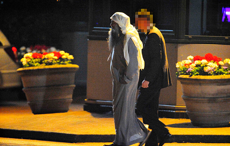 Abu Qatada leaves: Abu Qatada walks with an officer to board a small aircraft 