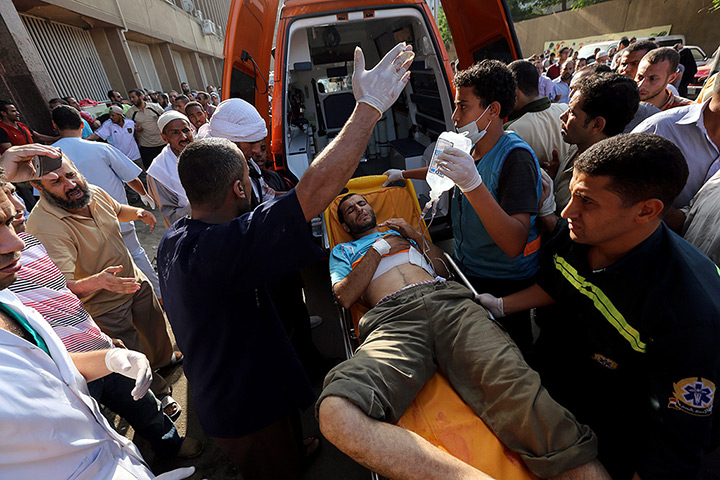 Egypt violence: Members of the Muslim Brotherhood carry an injured supporter of Morsi durin