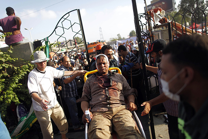 Egypt violence: A injured man is wheeled into a makeshift hospital following clashes betwee