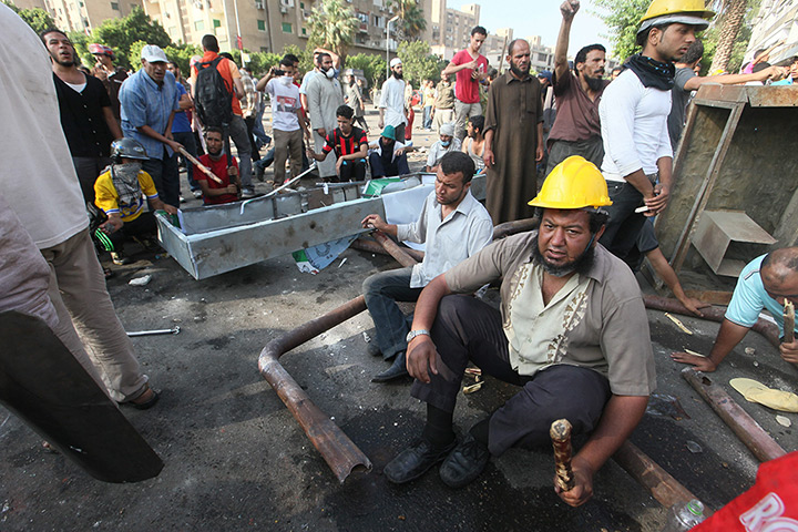 Egypt violence: Muslim Brotherhood members gather behind barricades during clashes with Rep