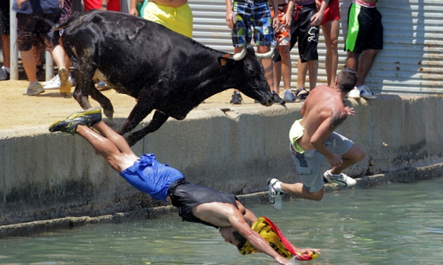 People jump with a bull into the sea during the traditional running of 'Bous a la mar' (Bull in the sea) at Denia's harbour, near Alicante, Spain.