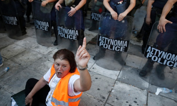 A municipal worker shouts slogans in front of riot police outside the Interior Ministry during a rally against public sector reforms in Athens, Greece.