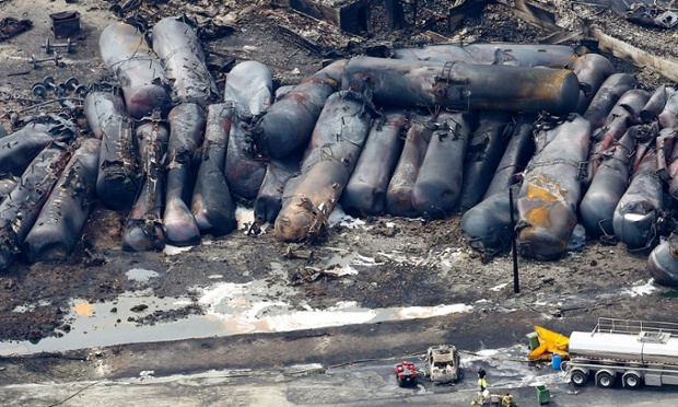 A firefighter stands close to the remains of a train wreckage in Lac Megantic, Canada. A driverless, runaway fuel train that exploded in a deadly ball of flames in the centre of a small Quebec town started rumbling down an empty track just minutes after a fire crew had extinguished a blaze in one of its parked locomotives.