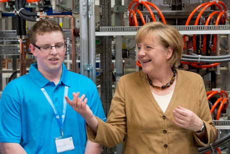 German Chancellor Angela Merkel (CDU) talks to trainee Francis Schwan during a visit of the company GE Energy in Berlin, Germany, 08 July 2013.