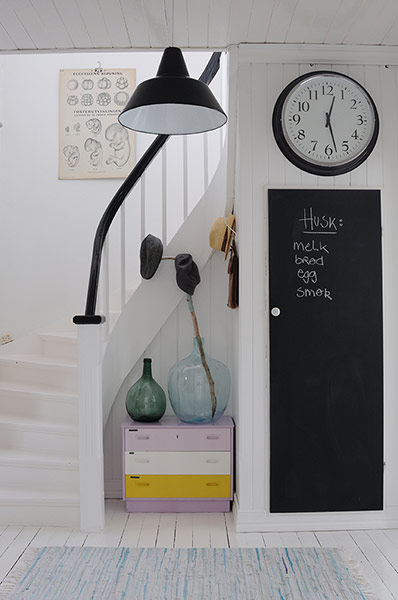homes - norway house: white hallway with stairs with black shade and clock