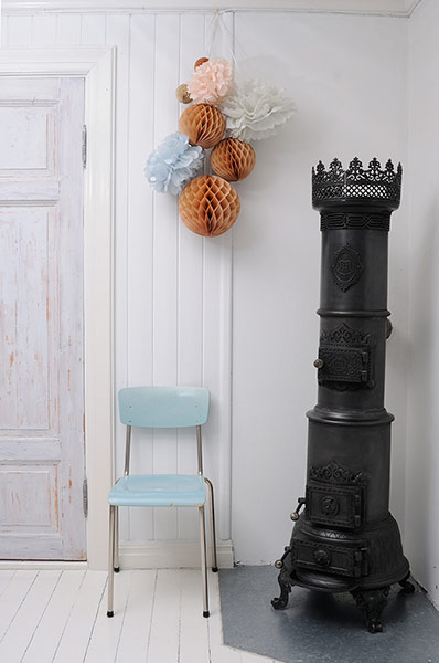 homes - norway house: white wall with pastel chair and cast iron oven 