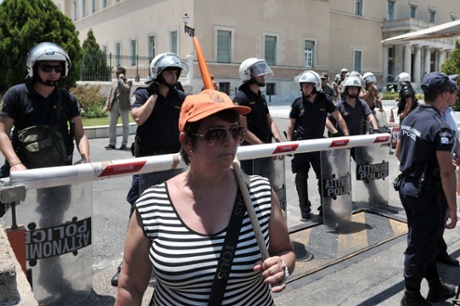 A striking municipal worker stands on July 9, 2013 in front of police forces protecting the Greek Parliament in Athens.