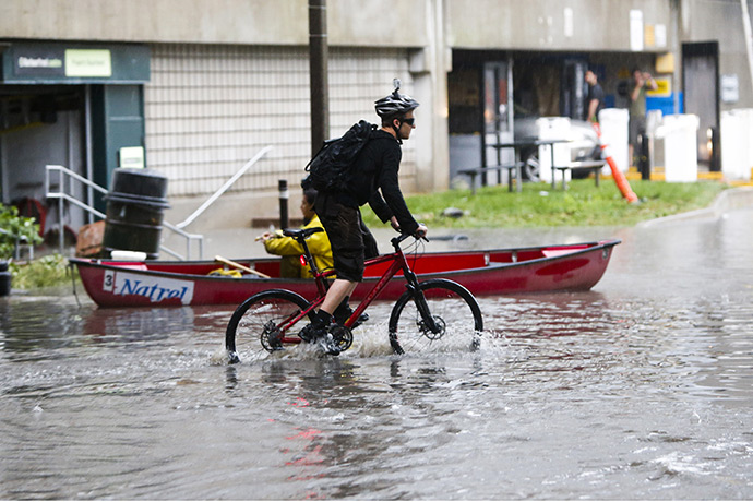 Canada floods: A man cycles in water downtown along Lake Shore Blvd West