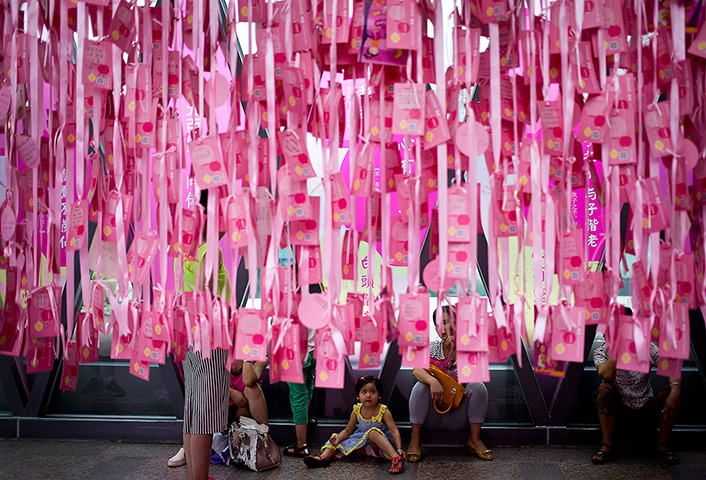 China Valentine's day: A child sits under message of love hanging at a shopping mall in Beijing, C