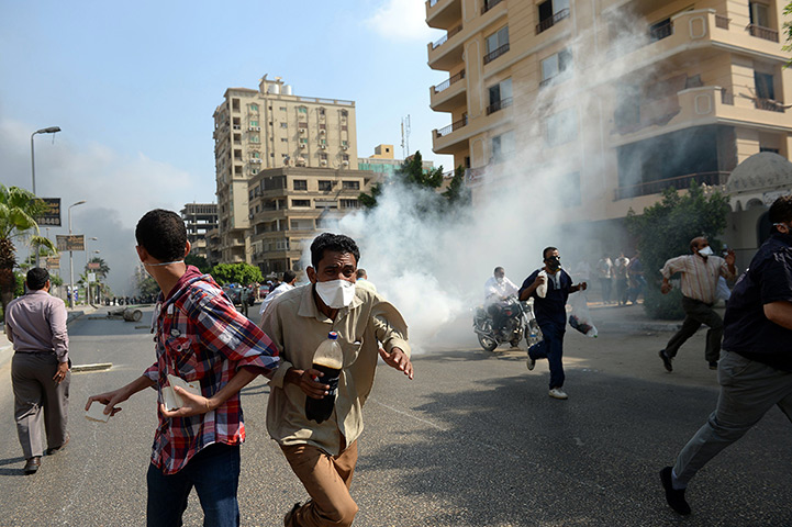 Egyptian camps: Muslim Brotherhood supporters run from tear gas in a street leading to the 