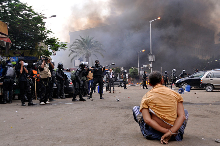 Egyptian camps: A handcuffed protester sits on the ground at a huge camp in Cairo's Al-Nahd