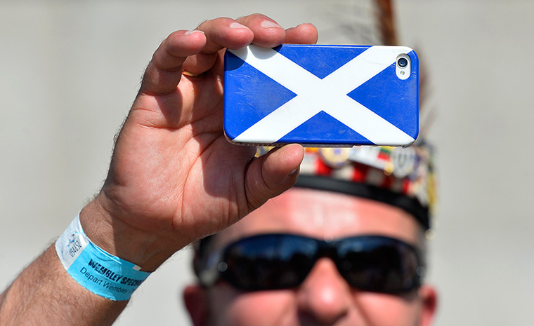 Scottish fans: A Scotland fan takes a photograph on a phone decorated with a Saltire desig