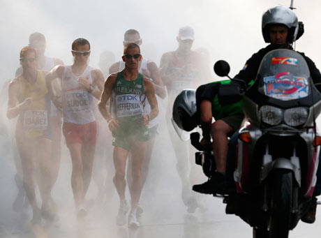 Competitors loom out of a cooling mist, led by evential winner Robert Heﬀernan of Ireland, in the   m