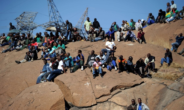 Another view of co-workers and relatives of 34 miners shot dead by South African police observing the first anniversary. Photograph: Stephane De SakutinAFP/Getty Images