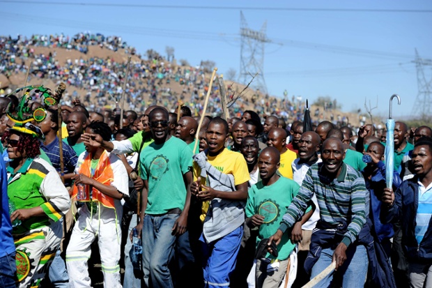 Co-workers and relatives of 34 miners shot dead by South African police during a violent wage strike sing and dance as they gather in Marikana to mark the first anniversary of their deaths. The August shooting was described as the worst police brutality since the end of apartheid two decades ago. Photograph: Stephane De Sakutin/AFP/Getty Images