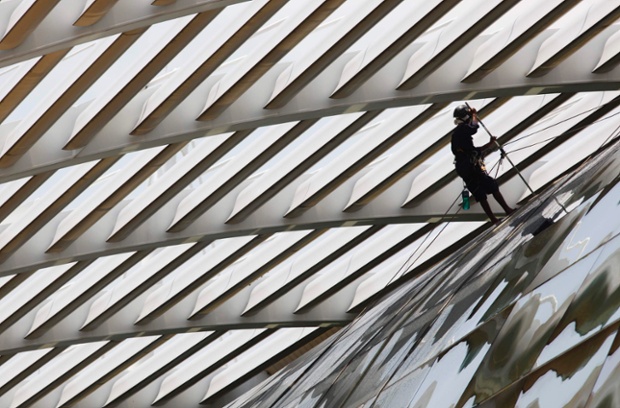A worker cleans the glass facade of a mall in Singapore. Photograph: Edgar Su/Reuters