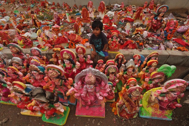 A child sits amidst the idols of Hindu goddess Dashama in Ahmadabad, India. The 10-day Dashama festival culminates with the immersion of the idol