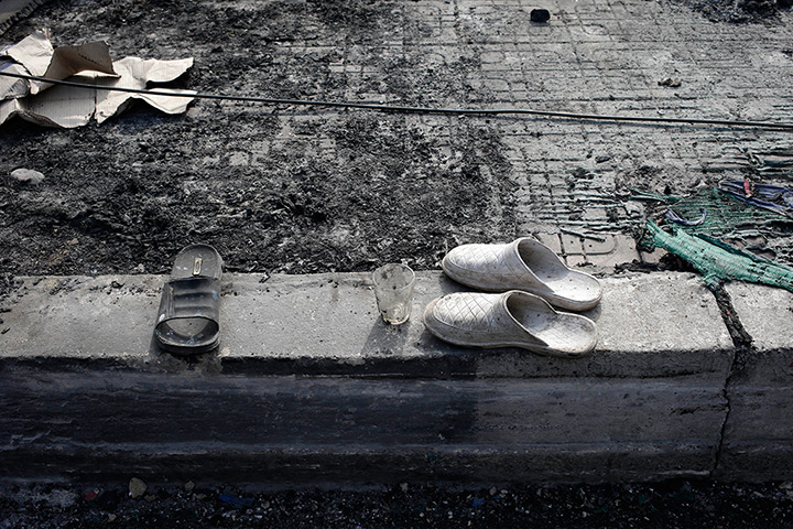 Abandoned shoes and a glass among the ashes